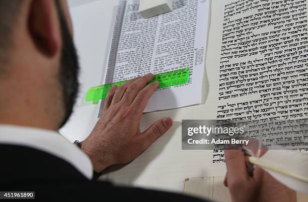 Rabbi and Torah Scribe Reuven Yaacobov copies by hand a section of the Torah with a quill pen on July 10, 2014 in the Jewish Museum in Berlin,...