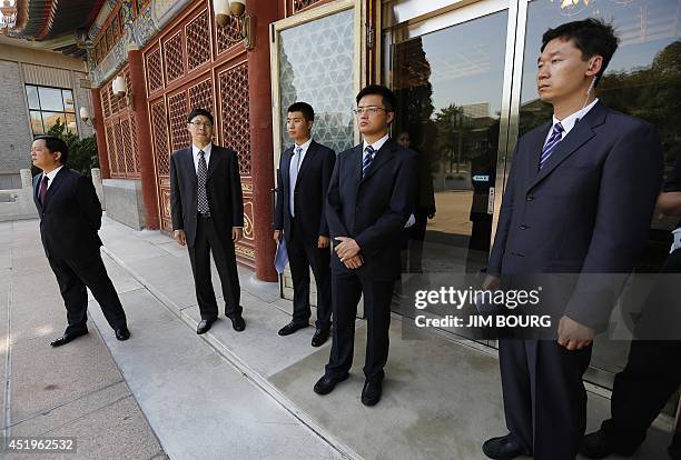 Chinese security agents stand guard outside the Purple Light Pavilion of the Zhongnanhai leadership compound as they await the arrival of US...