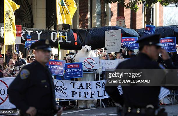 Protesters against the proposed Keystone XL pipeline hold placards across the street from where US President Barack Obama attends a Democratic Party...
