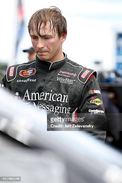 Brandon Gdovic, driver of the American Messaging/Windstax Chevrolet stands in the garage area during practice for the Granite State 100 in the K&N...