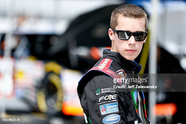 Ben Rhodes, driver of the Alpha Mechanical Chevrolet, stands in the garage area during practice for the Granite State 100 in the K&N Pro Series East...