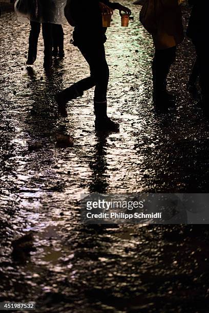 Festival-goer with two beers in his hands walks through mud at Openair Frauenfeld on July 10, 2014 in Frauenfeld, Switzerland.
