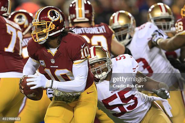 Quarterback Robert Griffin III of the Washington Redskins runs the ball as outside linebacker Ahmad Brooks of the San Francisco 49ers rushes in in...