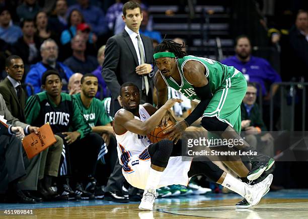 Kemba Walker of the Charlotte Bobcats and Gerald Wallace of the Boston Celtics fight for a loose ball during their game at Time Warner Cable Arena on...