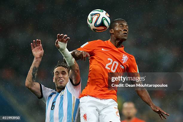Georginio Wijnaldum of the Netherlands competes for the header with Lucas Biglia of Argentina during the 2014 FIFA World Cup Brazil Semi Final match...
