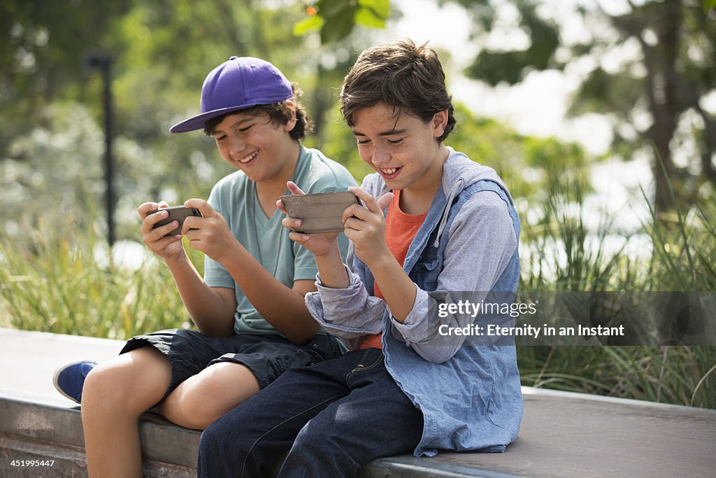 Boys hanging out playing games on their phones.