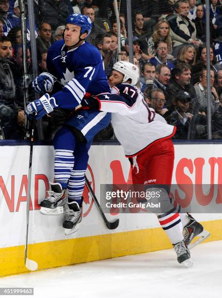 David Clarkson of the Toronto Maple Leafs jumps to avoid the check of Dalton Prout of the Columbus Blue Jackets during NHL game action November 25,...