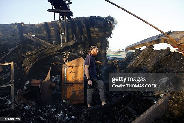 Canadian John Godfrey, a chief member of the peace activist boat "Gaza's Ark", checks the damage to his burnt boat following an Israeli air strike...