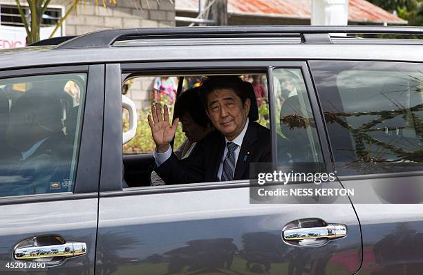 Japan's Prime Minister Shinzo Abe waves to the local during a visit to Wewak in Papua New Guinea on July 11, 2014. Abe is visiting New Zealand,...