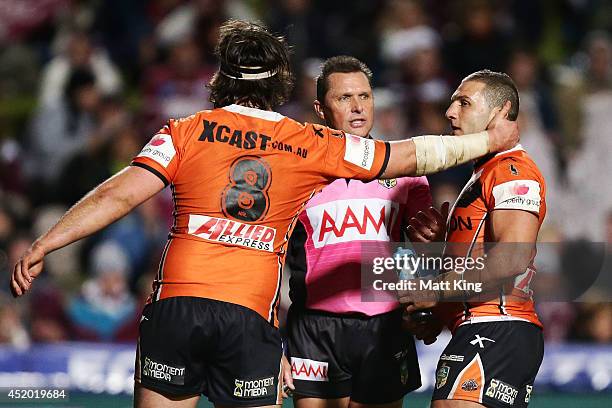 Robbie Farah of the Tigers argues with referee Shayne Hayne as Aaron Woods pulls him away during the round 18 NRL match between the Manly Warringah...