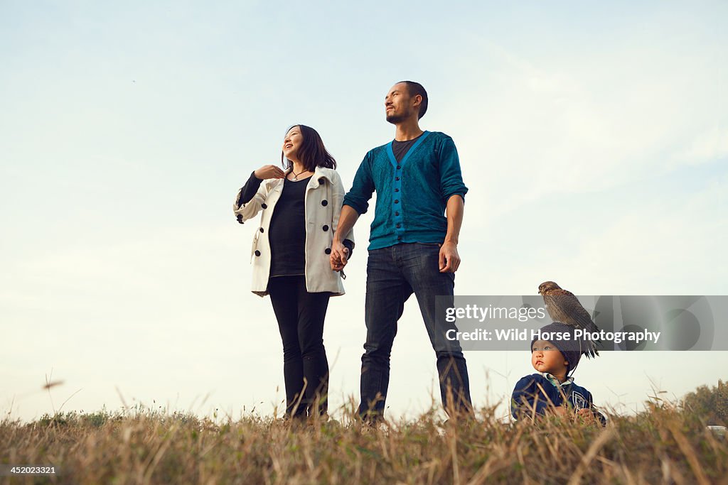 Family and falcon staring at the open field
