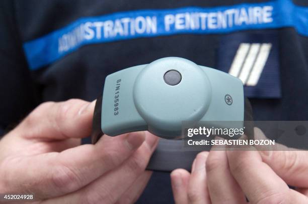 Prison agent shows an electronic ankle monitor during the visit of the French Justice minister Christiane Taubira at the SPIP in Besancon on July 11,...