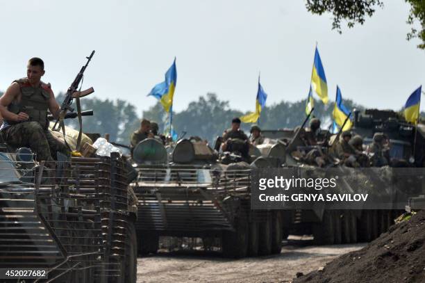 Ukrainian servicemen sitting atop armored personnel carriers travel near the eastern Ukrainian city of Slavyansk on July 11, 2014. Ukraine's military...