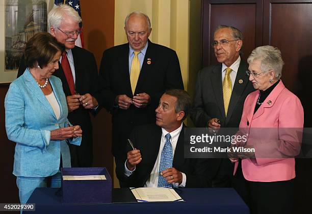 House Speaker John Boehner offers a pen to House Minority Leader Nancy Pelosi after signing the bipartisan legislation Workforce Innovation and...