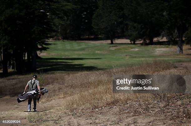 Golfer walkd on dead grass on a fairway at Gleneagles Golf Course on July 11, 2014 in San Francisco, California. As the severe drought in California...