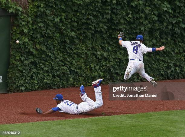 Chris Coghlan of the Chicago Cubs leaps to avoid colliding with teammate Junior Lake as they chase a ball hit by Jason Heyward of the Atlanta Braves...