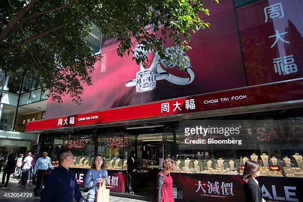 Pedestrians walk past a Chow Tai Fook Jewellery Group Ltd. Store in the shopping district of Tsim Sha Tsui in Hong Kong, China, on Tuesday, Nov. 26,...