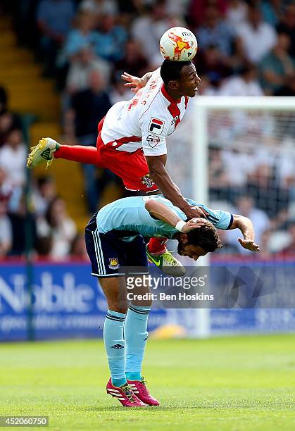 Darius Charles of Stevenage goes up for an aerial ball with Diego Poyet of West Ham during the Pre Season Friendly match between Stevenage and West...