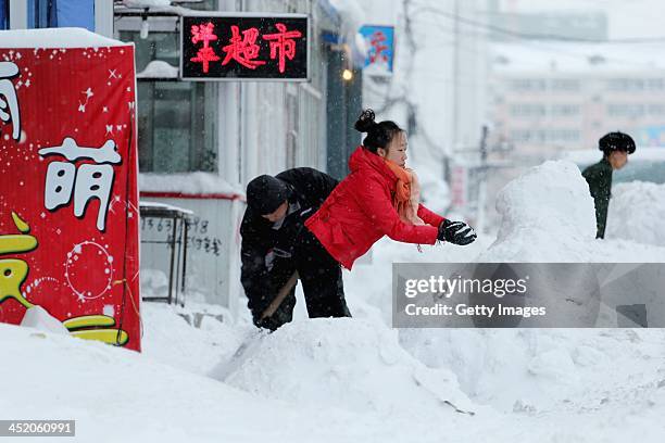 People clean road after blizzard at Xipingxing street on November 25, 2013 in Shuangyashan, Heilongjiang province of China. Highways and airports...