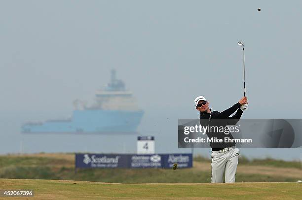 Justin Rose of England hits his approach shot on the 16th hole during the third round of the 2014 Aberdeen Asset Management Scottish Open at Royal...