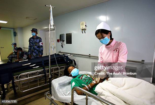 Philippino survivor receives treatment from Chinese Navy nurse at the Chinese Navy hospital ship on November 25, 2013 in Tacloban, leyte,...