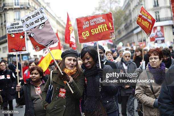 People hold boards which ask to raise wages and pensions and denouncing gifs for the rich during a demonstration of workers against a government...