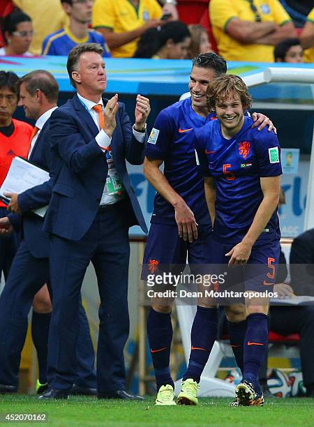 Daley Blind of the Netherlands celebrates scoring his team's second goal with Robin van Persie and head coach Louis van Gaal during the 2014 FIFA...