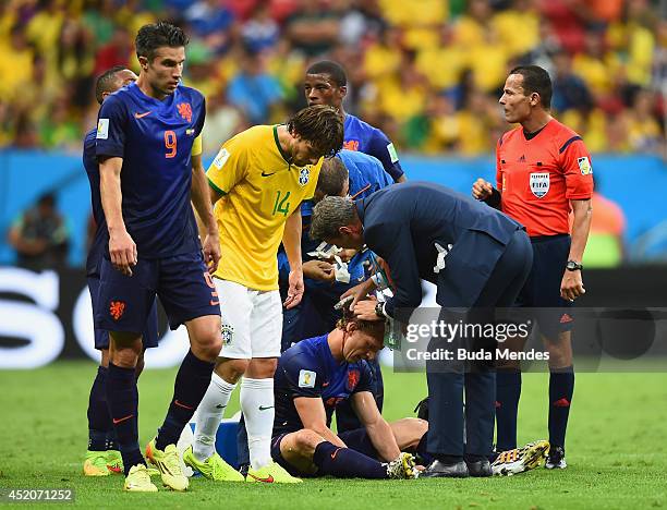 Dirk Kuyt of the Netherlands receives treatment after a clash as Maxwell of Brazil stands over during the 2014 FIFA World Cup Brazil Third Place...