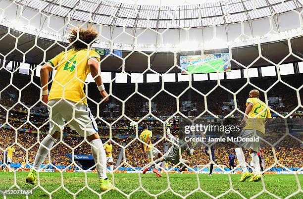 Daley Blind of the Netherlands scores his team's second goal past goalkeeper Julio Cesar and David Luiz of Brazil during the 2014 FIFA World Cup...