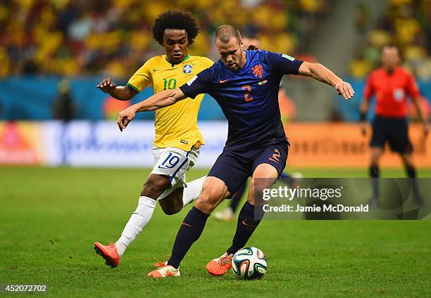 Ron Vlaar of the Netherlands controls the ball as Willian of Brazil gives chase during the 2014 FIFA World Cup Brazil Third Place Playoff match...