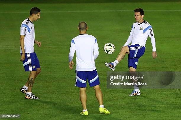 Angel di Maria, Javier Mascherano and Lionel Messi of Argentina warm up during the Argentina training session, ahead of the 2014 FIFA World Cup...