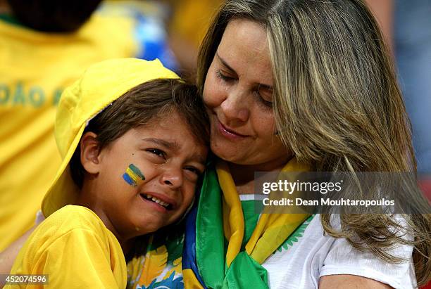 Young Brazil fan is consoled after being defeated by the Netherlands 3-0 during the 2014 FIFA World Cup Brazil Third Place Playoff match between...
