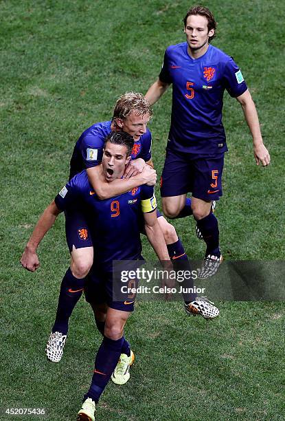 Robin van Persie of the Netherlands celebrates scoring his team's first goal on a penalty kick with Dirk Kuyt and Daley Blind during the 2014 FIFA...
