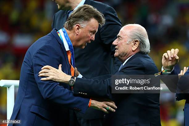 Head coach Louis van Gaal of the Netherlands is presented with his medal by FIFA President Joseph S. Blatter after defeating Brazil 3-0 during the...