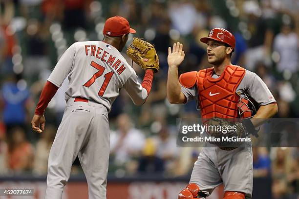 Sam Freeman the St. Louis Cardinals celebrates with George Kottaras after the 10-2 win over the Milwaukee Brewers at Miller Park on July 12, 2014 in...