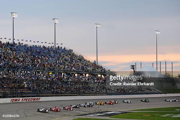 Helio Castroneves of Brazil, driver of the HItachi Team Penske Dallara Chevrolet, leads a pack of cars during the Iowa Corn Indy 300 at Iowa Speedway...