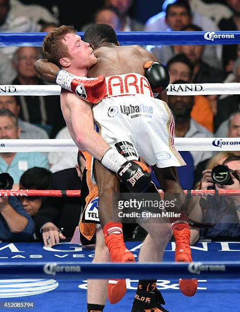 Canelo Alvarez lifts Erislandy Lara in the second round of their junior middleweight bout at the MGM Grand Garden Arena on July 12, 2014 in Las...