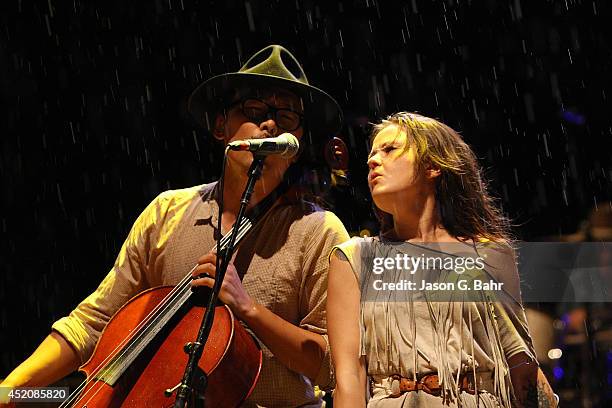 Joe Kwon and Tania Elizabeth of The Avett Brothers perform through the rain at Red Rocks Amphitheatre on July 12, 2014 in Morrison, Colorado.