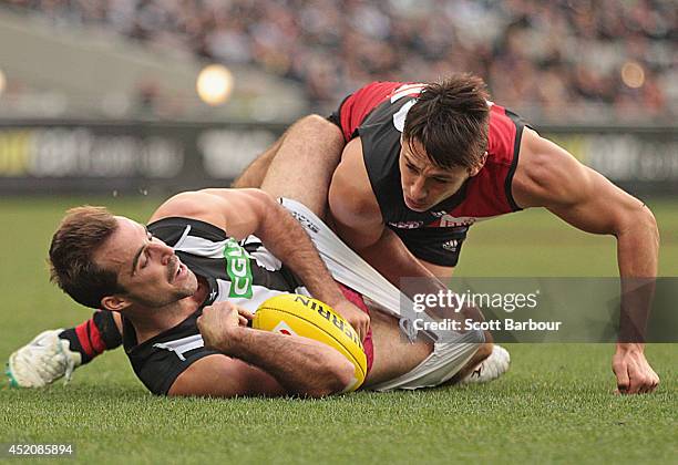 Steele Sidebottom of the Magpies and Mark Baguley of the Bombers compete for the ball during the round 17 AFL match between the Essendon Bombers and...