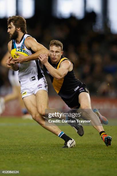 Justin Westhoff of the Power is tackled by Nathan Foley of the Tigers during the round 17 AFL match between the Richmond Tigers and the Port Adelaide...