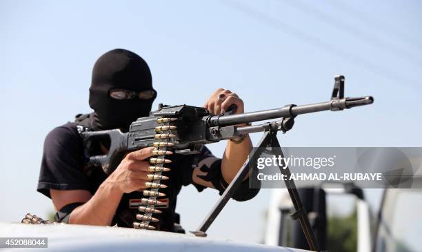 Shiites volunteers, loyal to Muslim Shiite cleric Moqtada al-Sadr, take positions during a military advance in areas under the control of Islamic...