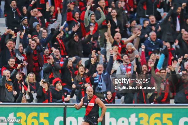 Paul Chapman of the Bombers celebrates after kicking a goal as Bombers supporters in the crowd cheer during the round 17 AFL match between the...
