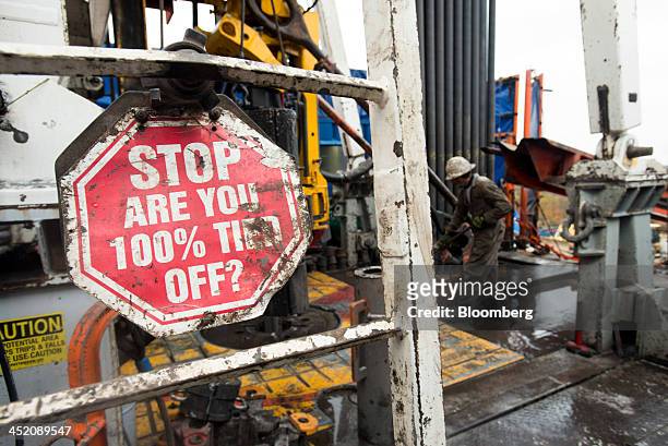 Safety signs are posted on a drilling rig at a hydraulic fracturing site owned by EQT Corp. Located atop the Marcellus shale rock formation in...