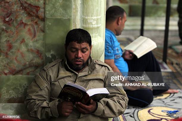 Shiites volunteers reads the Koran inside the Al-Askari shrine which is under repair, and embraces the tombs of the 10th and 11th Imams, Ali Al-Hadi...