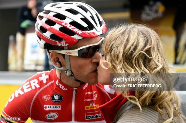 France's Tony Gallopin kisses his girlfriend French cyclist Marion Rousse as he leaves the signature ceremony before the start of the 170 km ninth...