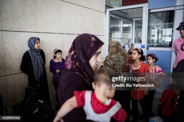 Gaza residents with dual nationality passports gather at the Erez crossing as they prepare to leave Gaza, on July 13, 2014 in Erez, Israel. Israel's...