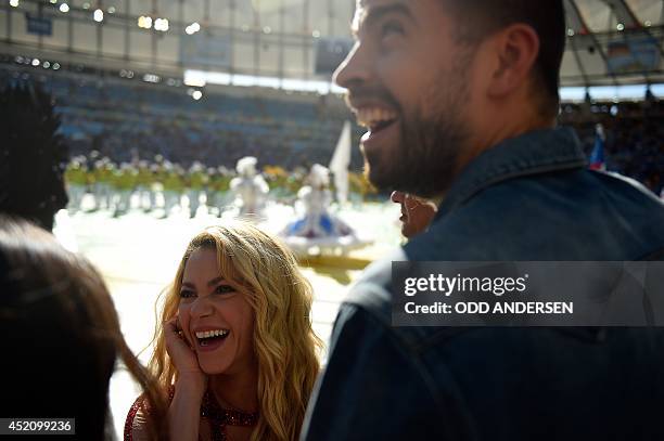 Colombian singer Shakira and her partner Barcelona's football player Gerard Pique smile during a closing ceremony ahead of the final football match...