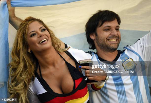 German supporter cheers for her team ahead of the final football match between Germany and Argentina for the FIFA World Cup at The Maracana Stadium...