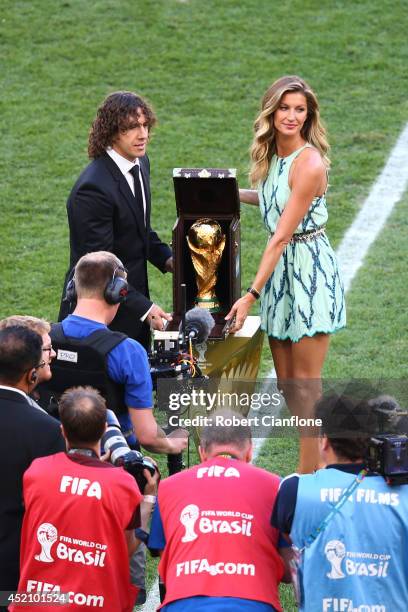 Former Spanish international Carles Puyol and model Gisele Bundchen present the World Cup trophy in a Louis Vuitton case prior to the 2014 FIFA World...