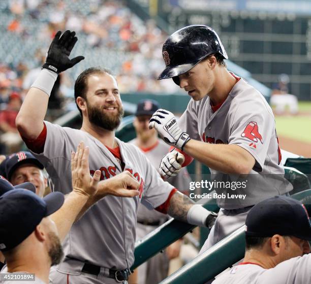 Brock Holt of the Boston Red Sox revceives high fives from Mike Napoli after hitting a home run in the first inning against the Houston Astros at...